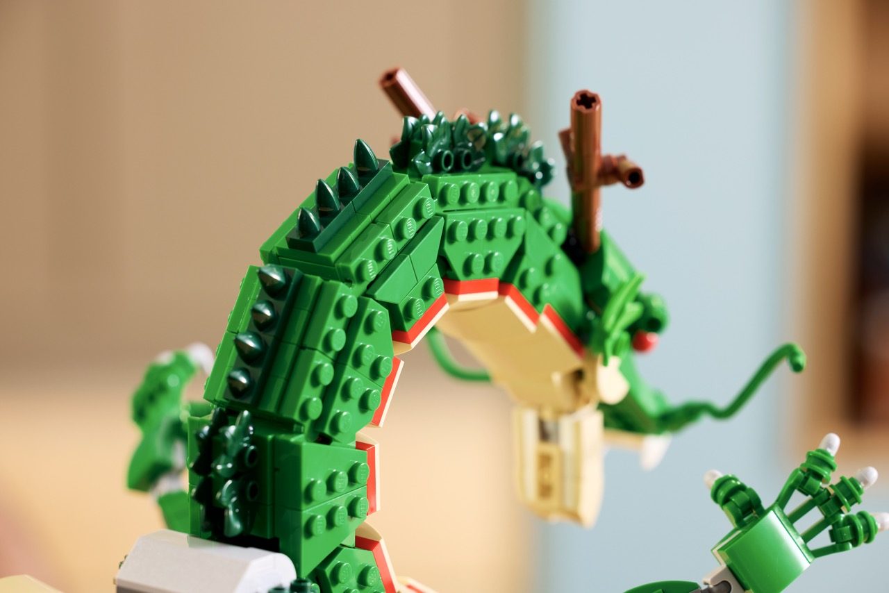 LEGO Shenron dragon set featuring green brick construction with spikes, red roof details, and brown staff pieces.