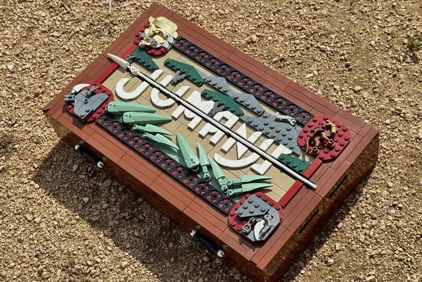 LEGO Jumanji set with brown base, green mechanical elements, white details, and red accents on display.