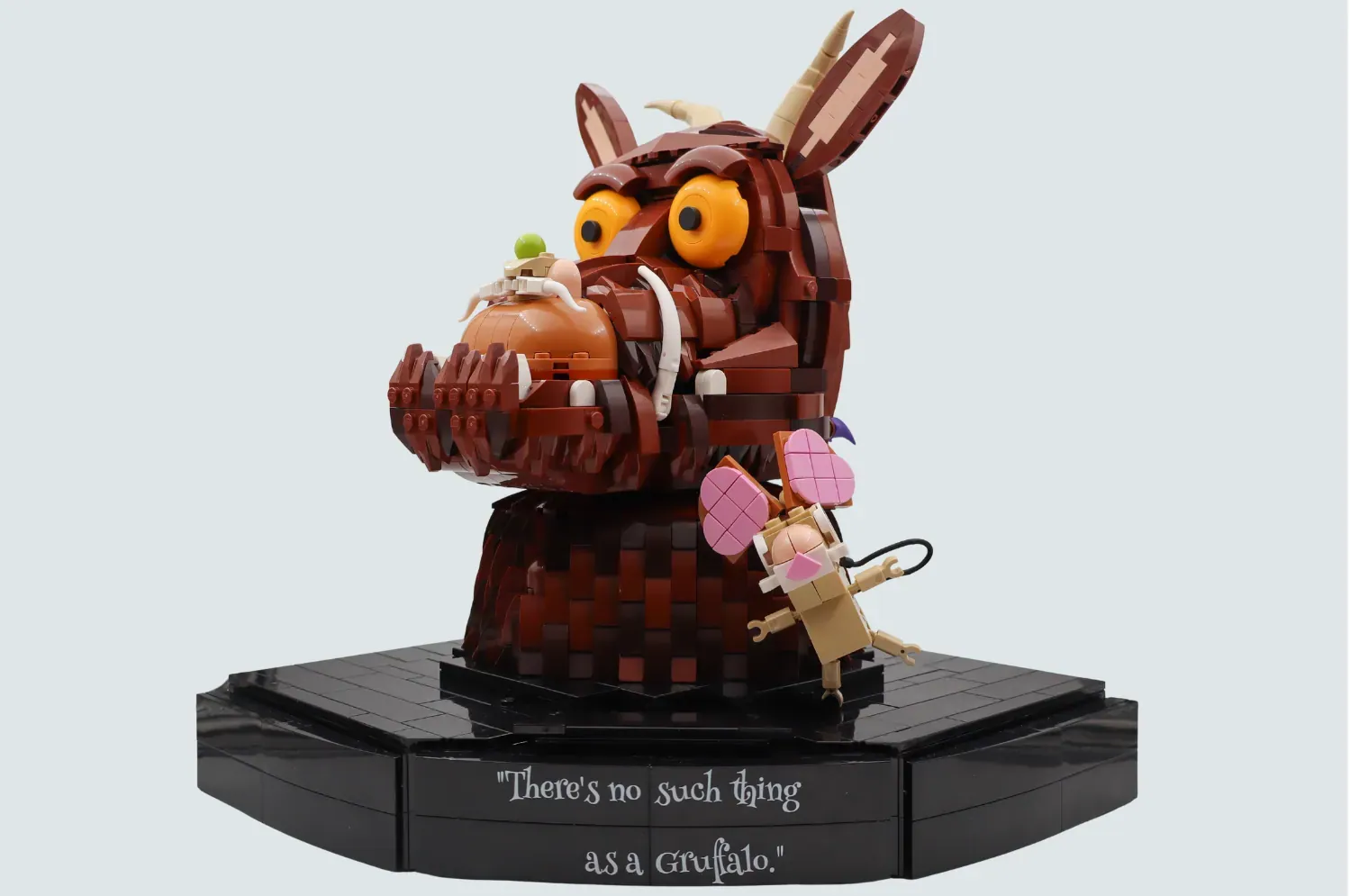 LEGO Gruffalo figure with large eyes holding a small mouse, on black base with quote engraved.