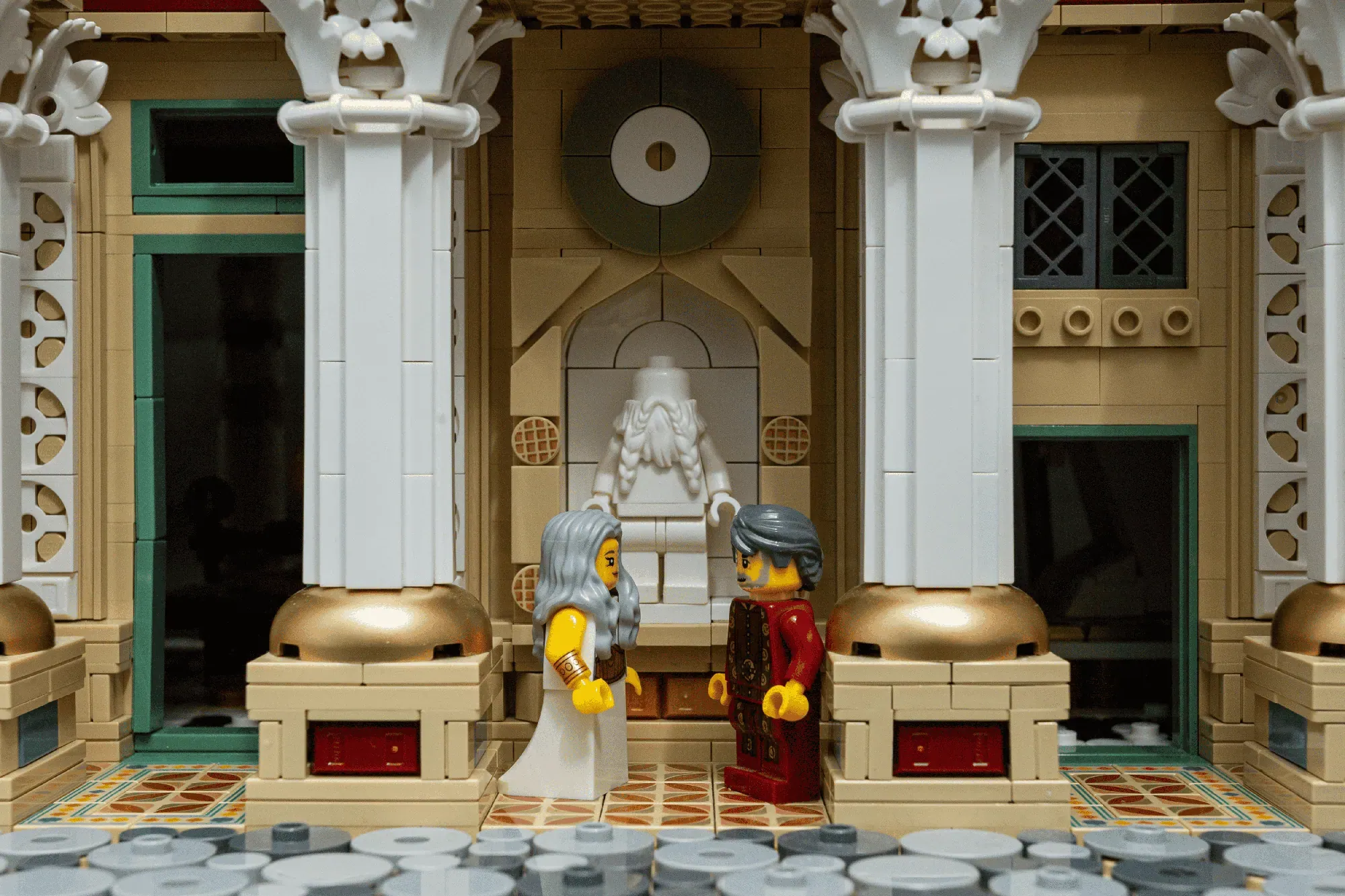 LEGO Ancient Library set featuring two minifigures in a grand hallway with marble columns, ornate architecture, and classi…