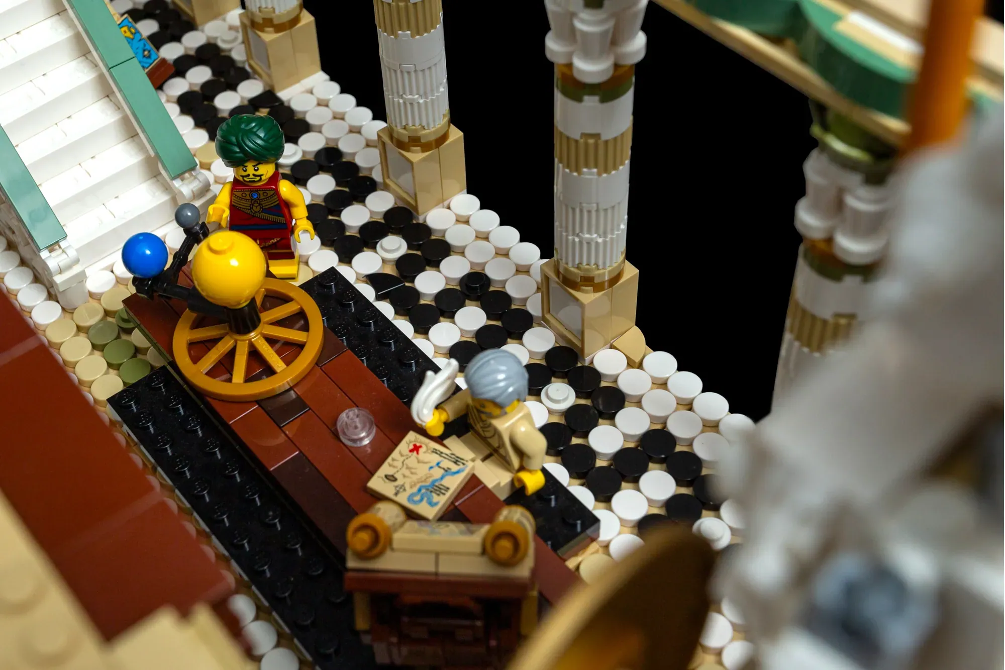 LEGO minifigures on a checkered floor beside ornate columns in an ancient library-themed MOC build.