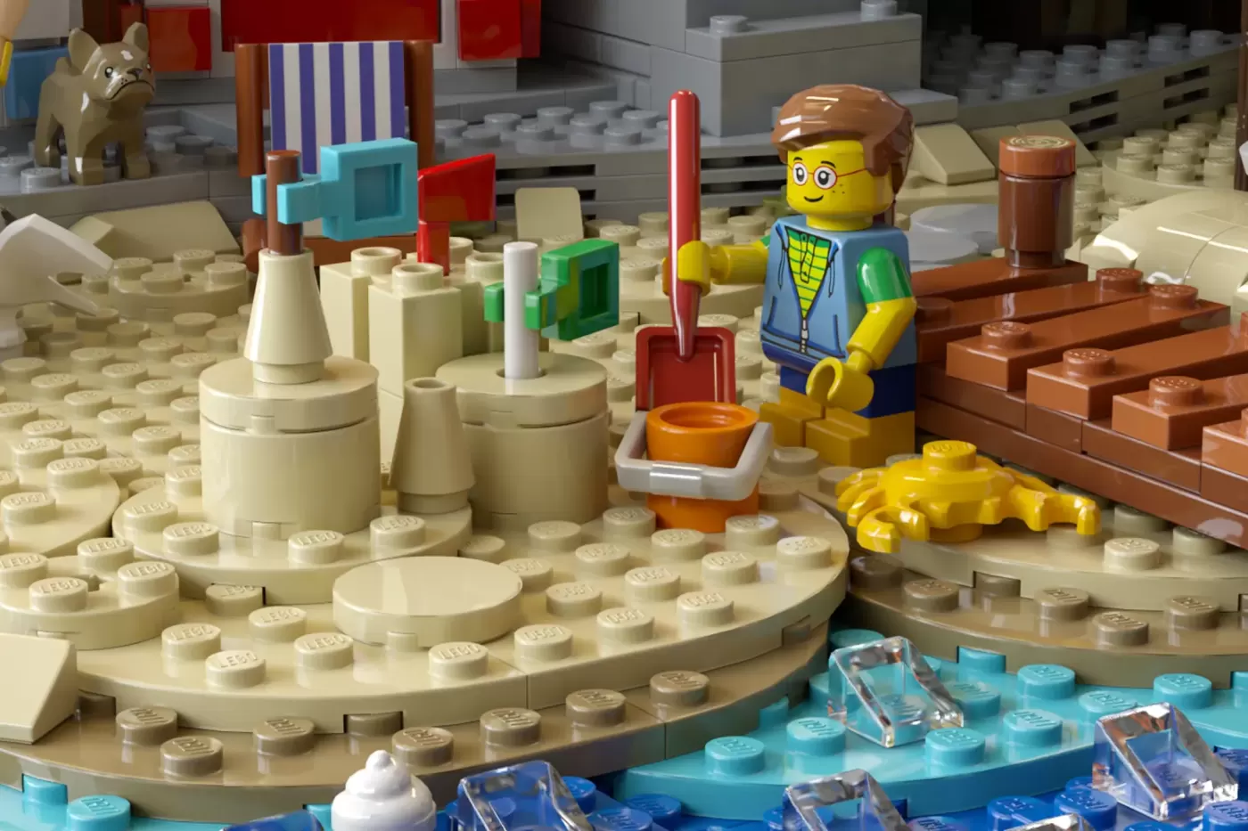 LEGO Victorian pier scene with minifigure worker, sand baseplate, seaside structures, and beach accessories.