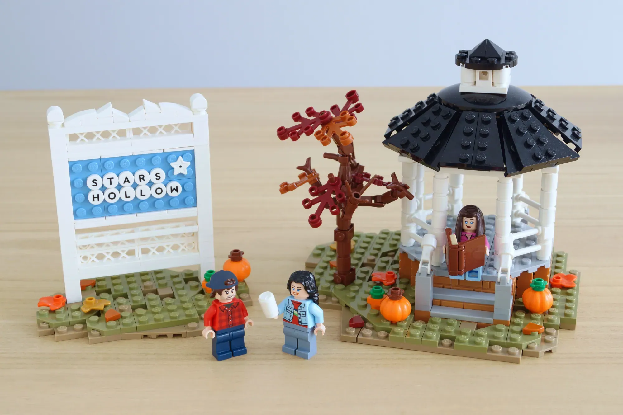 LEGO Stars Hollow gazebo, diner, and buildings with minifigures and autumn decorations on green baseplate.