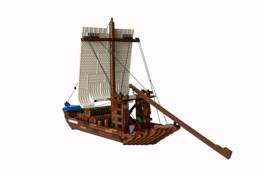 LEGO Barco Rabelo ship model with tan sail, brown wooden hull, cargo barrels, and extended oar.