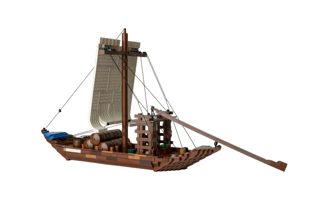 LEGO Barco Rabelo model featuring brown brick hull, sail, cargo barrels, cabin structure, and rigging on white background.