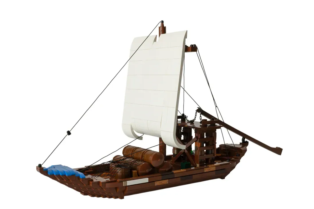 LEGO Barco Rabelo model with white sail, brown wooden hull, cargo details, and rigging on white background.