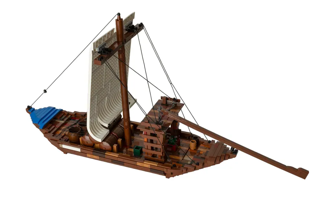 LEGO Barco Rabelo with brown wooden hull, blue cabin, white sail, mast, and oar.
