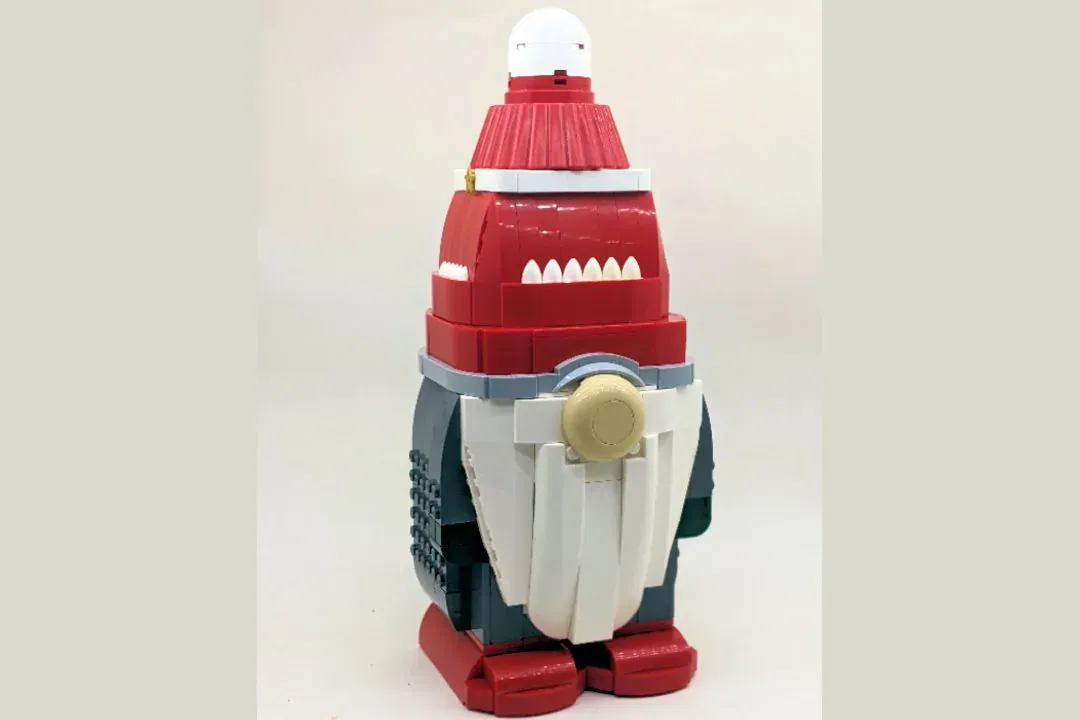 LEGO Christmas gnome figure with red hat, white beard, dark coat, and red feet, approximately 30 cm tall.