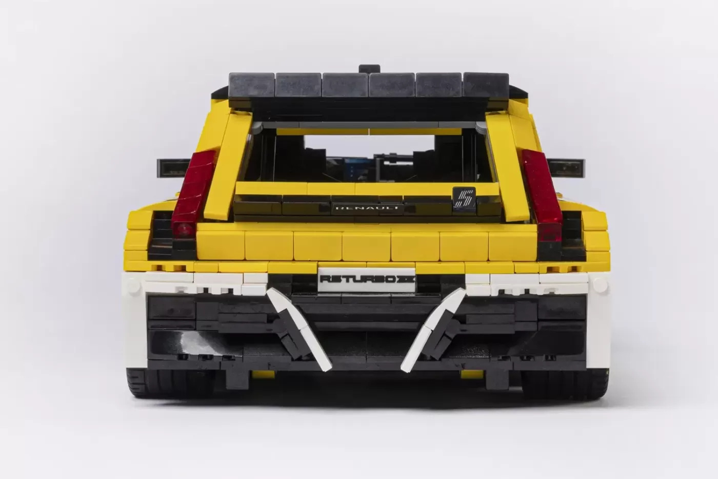 LEGO Renault 5 Turbo 3E model in yellow, black and white, rear view showing bumper and exhaust details.