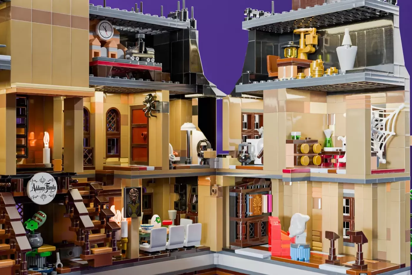 LEGO Addams Family Mansion cross-section showing multiple rooms with gothic decor, furniture, and details across three lev…