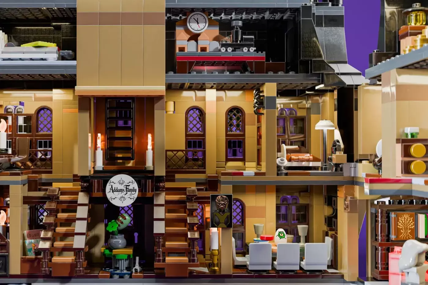 LEGO Addams Family mansion cross-section showing interior rooms, purple accents, ornate doors, staircase, and detailed fur…