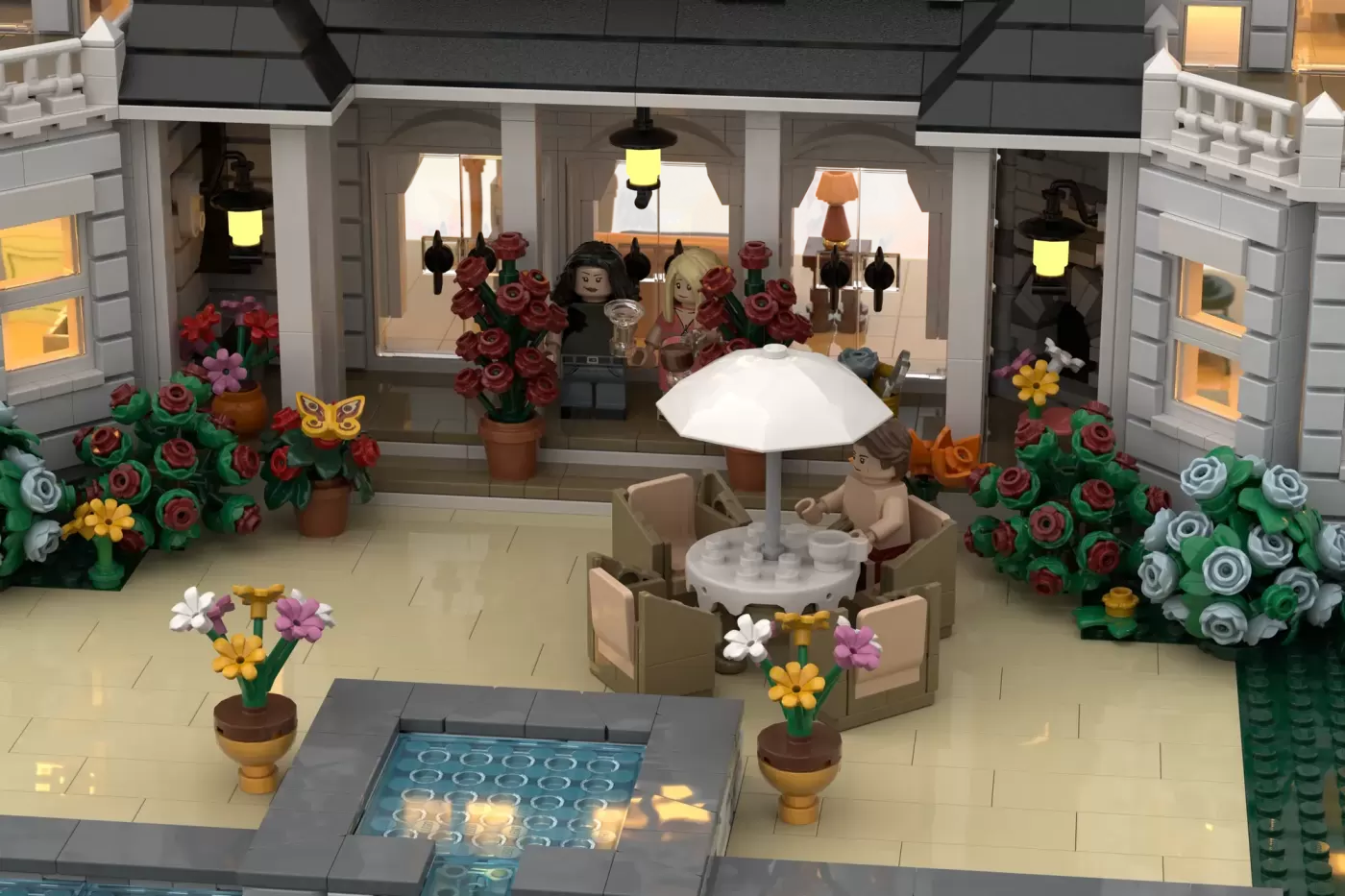 LEGO fan-built summer resort storefront with minifigures, flowering plants, umbrella seating area, and illuminated windows.