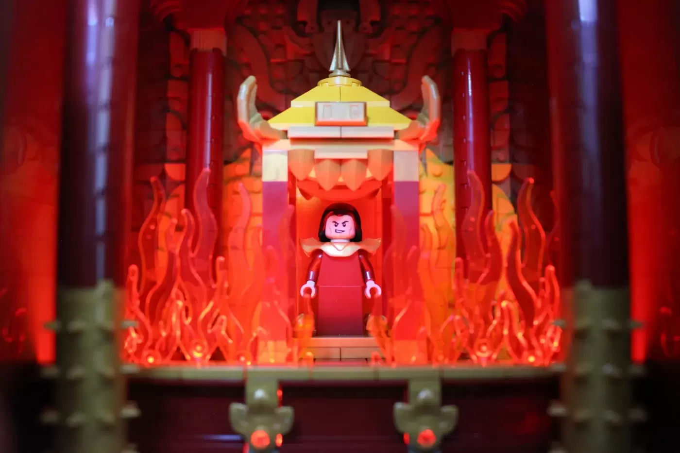 LEGO Fire Nation Palace set with red-robed minifigure, golden pagoda roof, flaming walls, and ornate architecture.