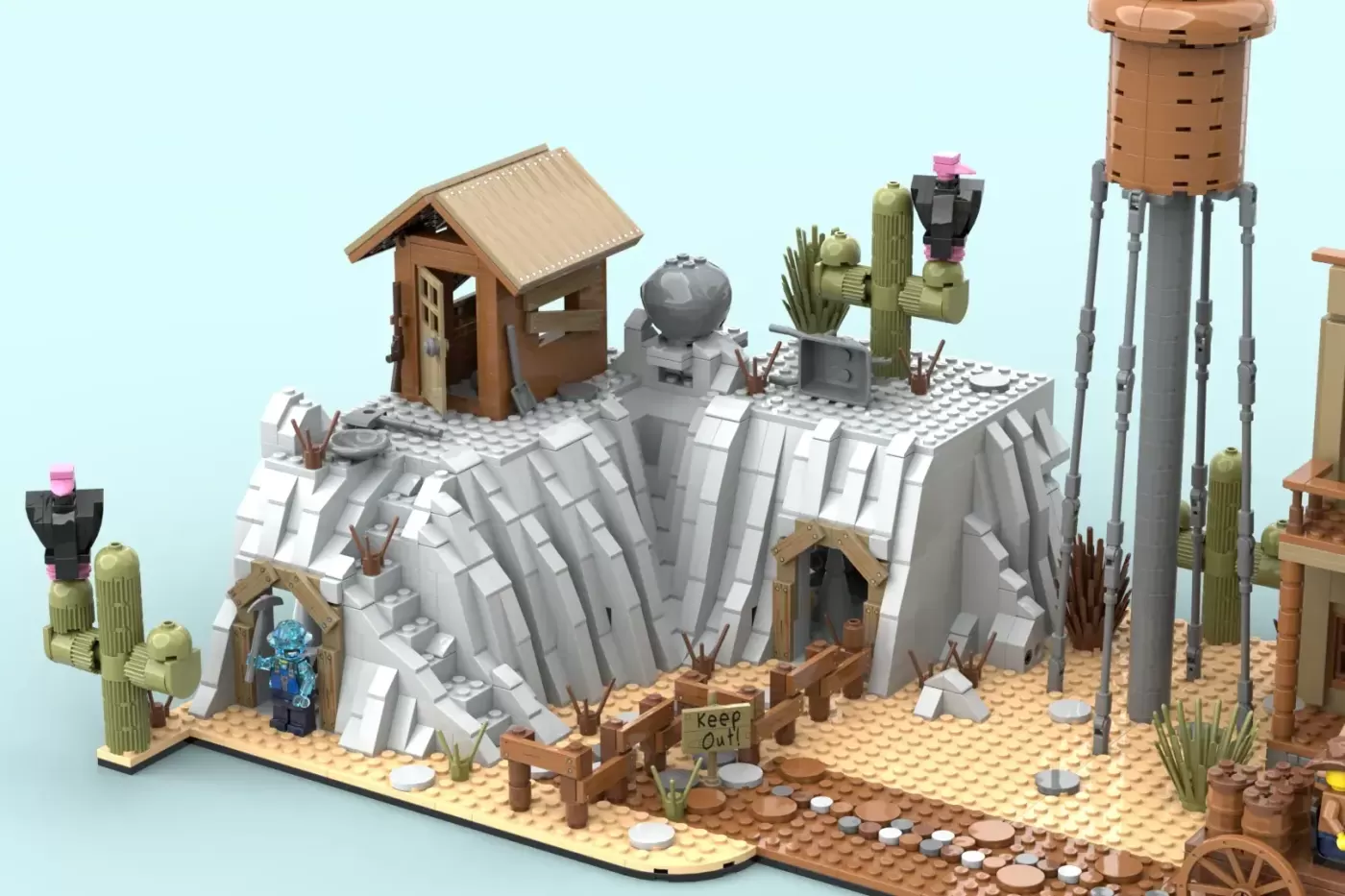 LEGO Western town scene with mining shack, water tower, cacti, and minifigures on tan baseplate.
