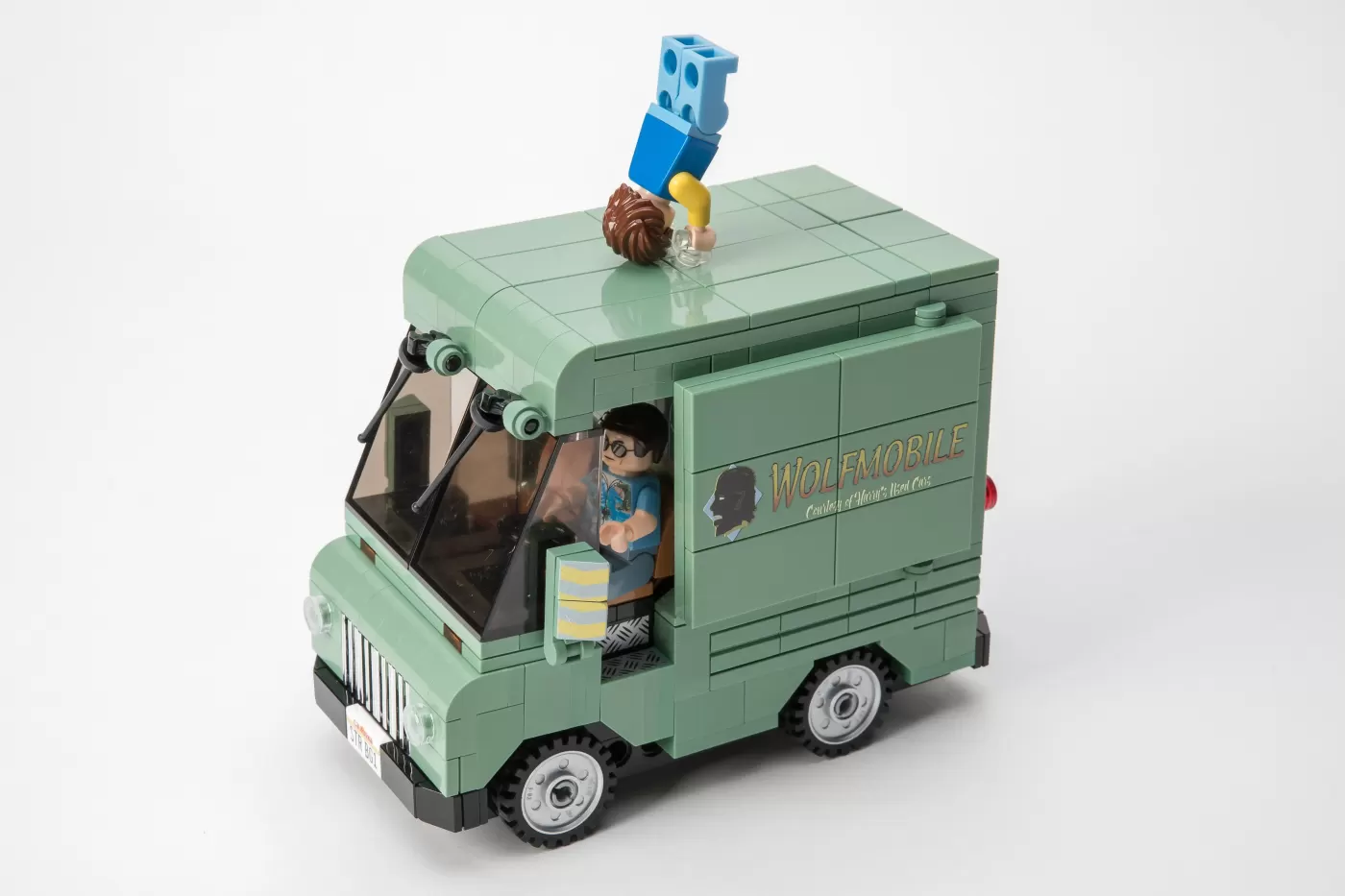 LEGO Wolfmobile set with minifigures and a brick-built green van featuring "Wolfmobile" text on the side.